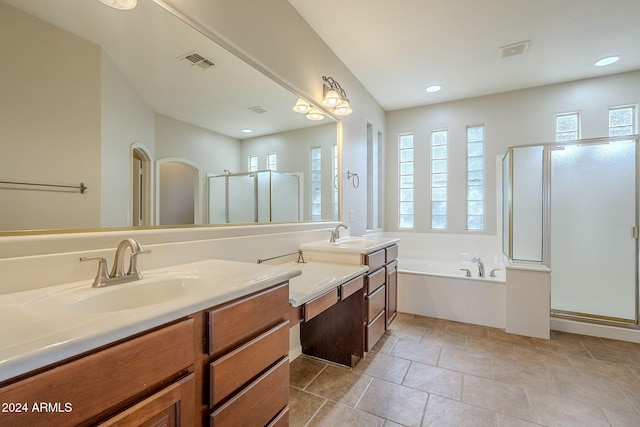 bathroom with vanity and shower with separate bathtub