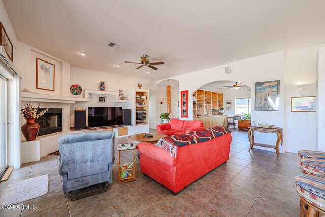 1880 W Roderick Ln, Wickenburg, AZ 85390 - living room with tile patterned floors, visible vents, a fireplace, and a ceiling fan