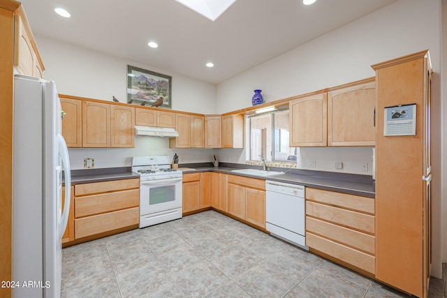 kitchen with light brown cabinetry, white appliances, and sink