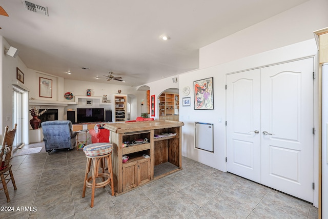 kitchen with ceiling fan, light tile patterned floors, and a breakfast bar area