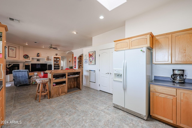1880 W Roderick Ln, Wickenburg, AZ 85390 - kitchen with dark countertops, arched walkways, visible vents, a ceiling fan, and white fridge with ice dispenser