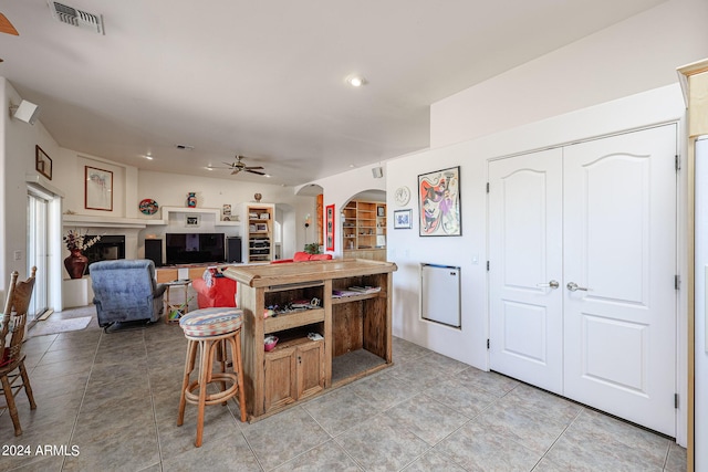1880 W Roderick Ln, Wickenburg, AZ 85390 - kitchen featuring a kitchen island, arched walkways, light tile patterned flooring, visible vents, and a ceiling fan