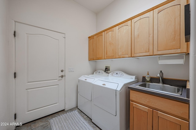 laundry room featuring cabinets, tile patterned flooring, washing machine and dryer, and sink