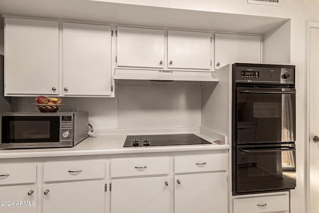 kitchen with black appliances and white cabinetry