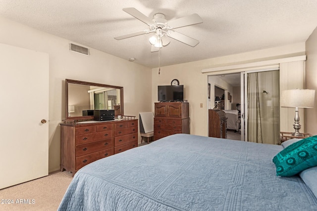 carpeted bedroom with a textured ceiling and ceiling fan