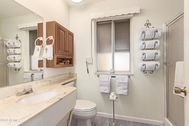 bathroom featuring hardwood / wood-style floors, vanity, toilet, and walk in shower