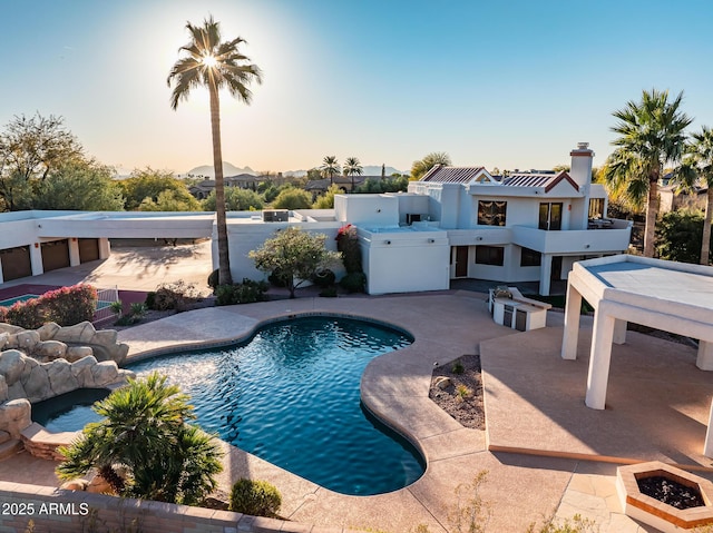 pool at dusk featuring a patio