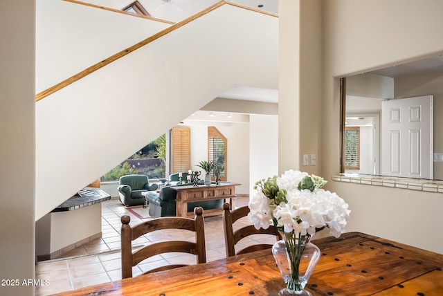 tiled dining room featuring a towering ceiling