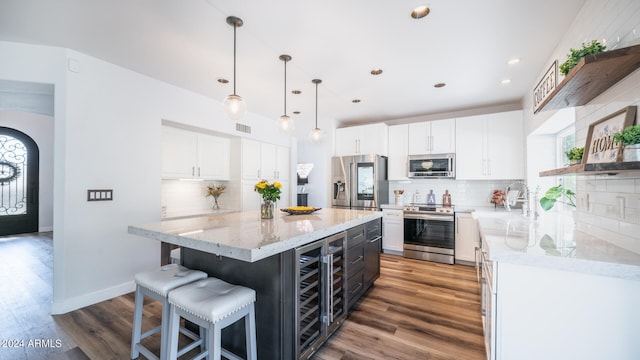 kitchen with wine cooler, stainless steel appliances, hardwood / wood-style floors, and white cabinets