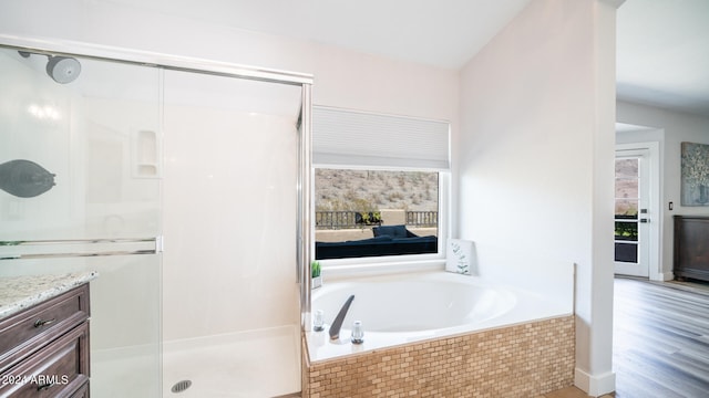 bathroom featuring vanity, hardwood / wood-style floors, and plus walk in shower