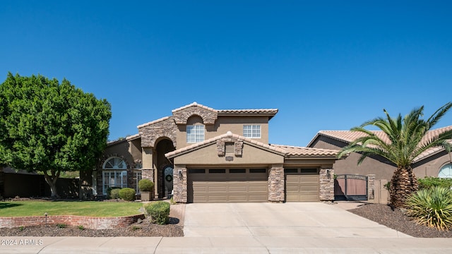 mediterranean / spanish-style home featuring a front yard and a garage