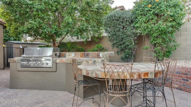 view of patio featuring exterior bar, an outdoor kitchen, and grilling area