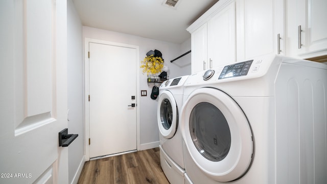 laundry area featuring dark wood-type flooring, cabinets, and separate washer and dryer