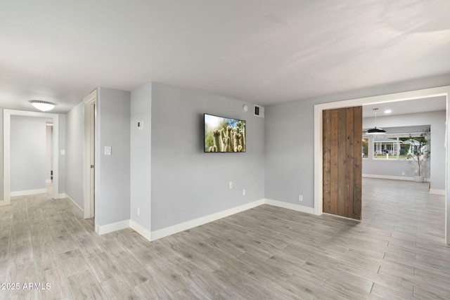 spare room with light wood-style flooring and baseboards