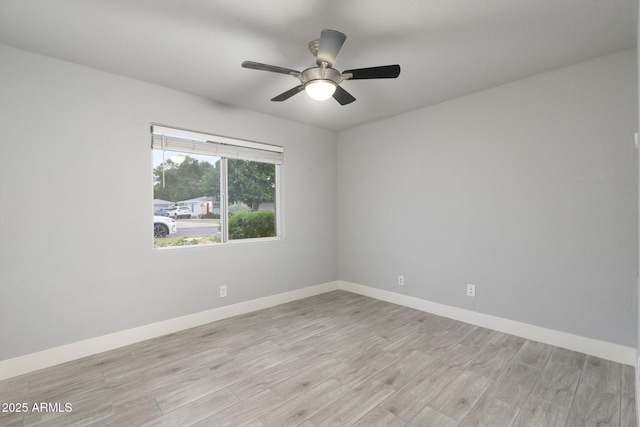 empty room with light wood-type flooring, baseboards, and a ceiling fan