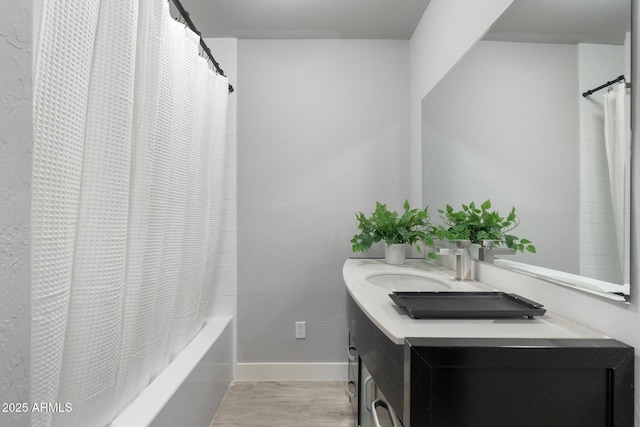 bathroom with baseboards, vanity, and shower / bath combination with curtain