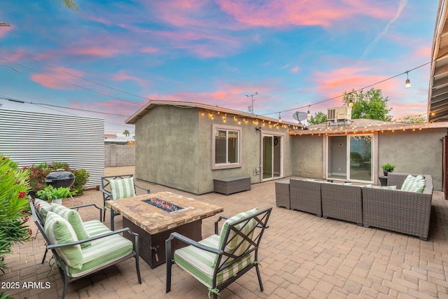 view of patio featuring an outdoor living space with a fire pit and central AC
