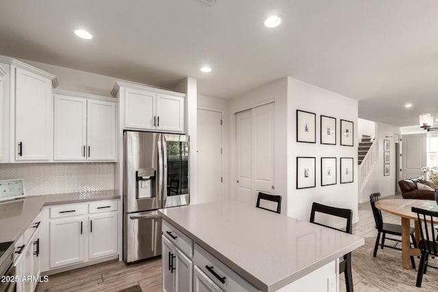 5460 S Dillon Cir, Mesa, AZ 85212 - kitchen featuring stainless steel refrigerator with ice dispenser, white cabinetry, open floor plan, decorative backsplash, and light countertops