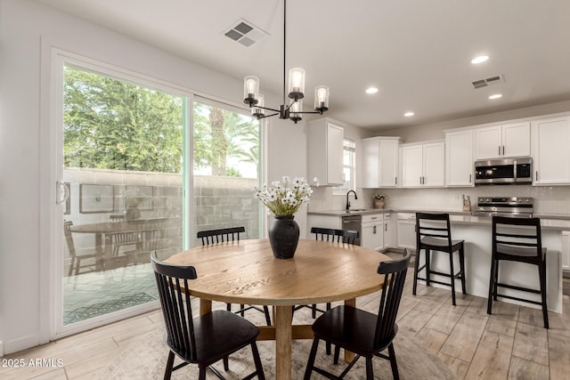 5460 S Dillon Cir, Mesa, AZ 85212 - dining space with healthy amount of natural light, a chandelier, light wood-style flooring, and recessed lighting