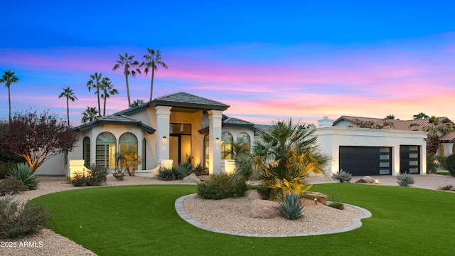 view of front of house with a garage and a lawn