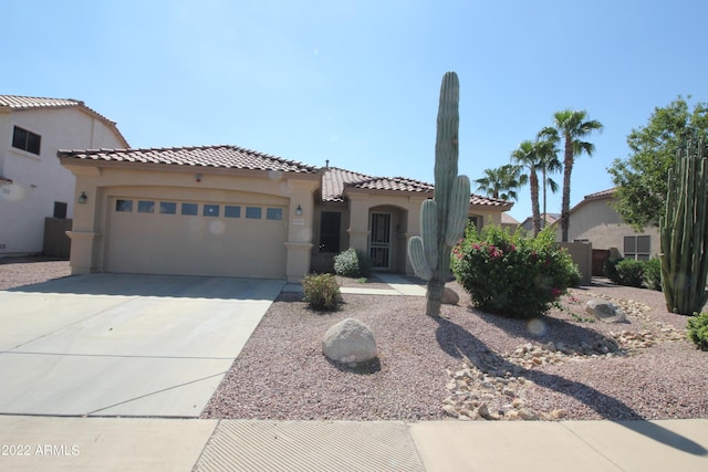 mediterranean / spanish-style house with driveway, an attached garage, a tile roof, and stucco siding