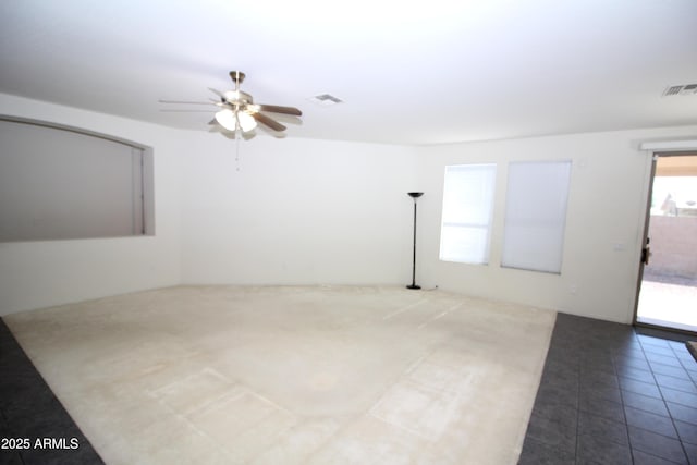 empty room with tile patterned flooring, visible vents, and ceiling fan