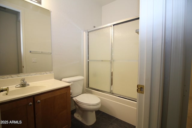 bathroom featuring combined bath / shower with glass door, vanity, toilet, and tile patterned floors