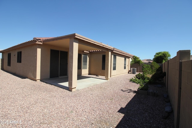 rear view of house featuring a tile roof, a patio, stucco siding, cooling unit, and a fenced backyard