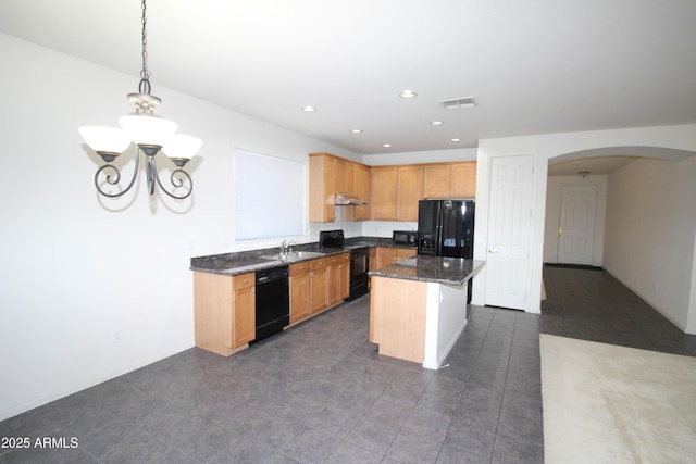 kitchen featuring arched walkways, under cabinet range hood, a kitchen island, visible vents, and black appliances