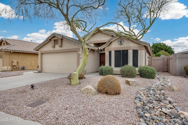 view of front facade featuring driveway, a garage, fence, and stucco siding