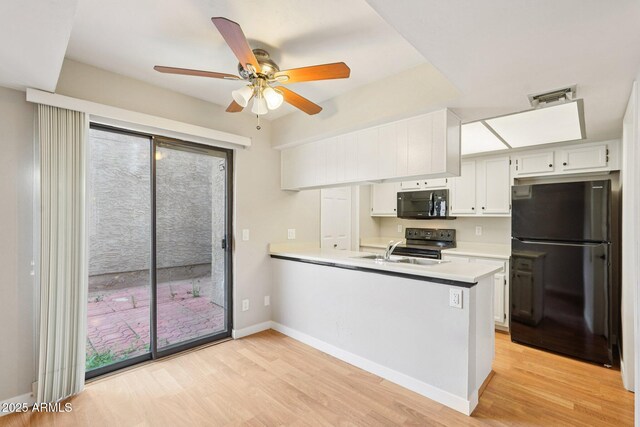 2815 N 52nd St Unit 3, Phoenix, AZ 85008 - kitchen with black appliances, a peninsula, light countertops, and light wood-style flooring