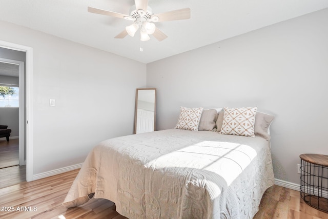 bedroom featuring ceiling fan, baseboards, and wood finished floors