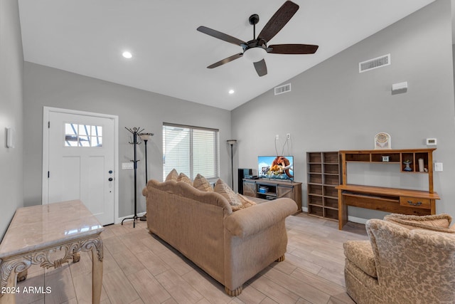 living room featuring vaulted ceiling, light hardwood / wood-style flooring, and ceiling fan