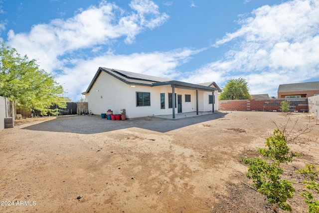 back of property featuring a patio area and solar panels