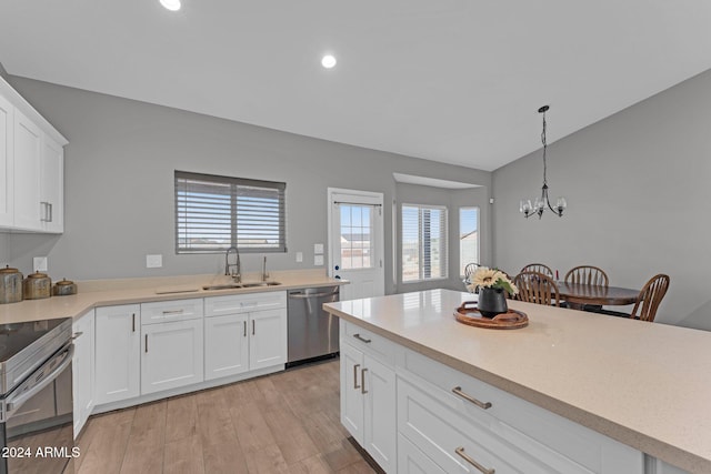 kitchen with sink, pendant lighting, white cabinetry, appliances with stainless steel finishes, and light hardwood / wood-style floors