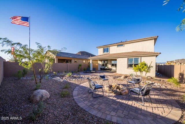 12233 W Caraveo Pl, Peoria, AZ 85383 - rear view of house with stucco siding, a fenced backyard, a patio area, and an outdoor fire pit