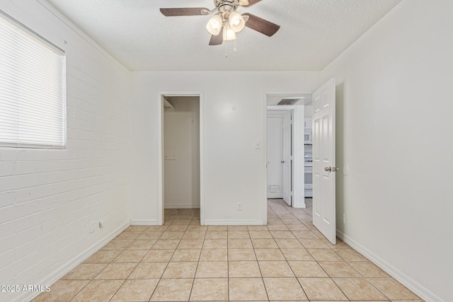 3128 W Pima St Unit 2, Phoenix, AZ 85009 - unfurnished bedroom featuring a textured ceiling, a walk in closet, light tile patterned flooring, and a ceiling fan