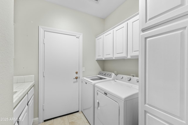 laundry area with separate washer and dryer and cabinets