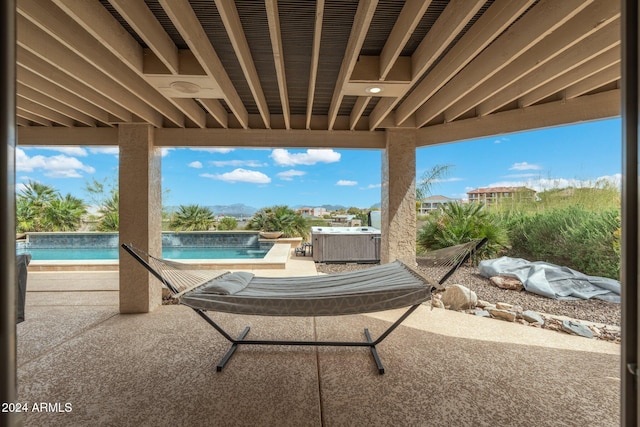 view of patio / terrace with a swimming pool with hot tub