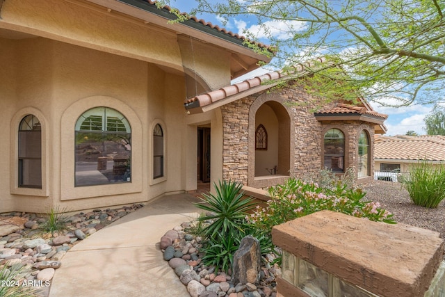 15857 E Ponderosa Dr, Fountain Hills, AZ 85268 - view of exterior entry with a tile roof, stucco siding, and stone siding