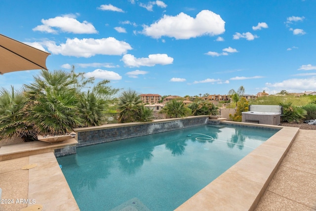 view of swimming pool with a hot tub