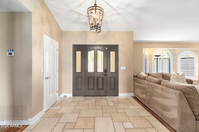 foyer with a healthy amount of sunlight and a notable chandelier