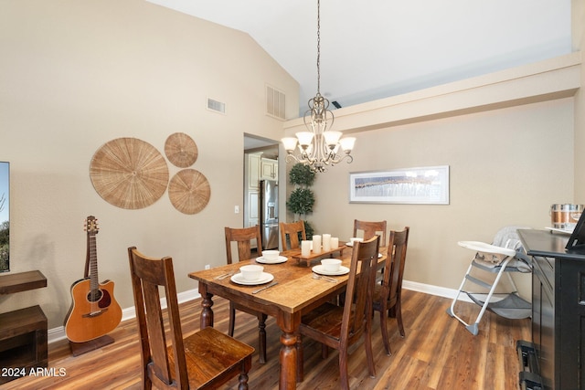 dining area featuring a notable chandelier, dark wood-type flooring, and vaulted ceiling