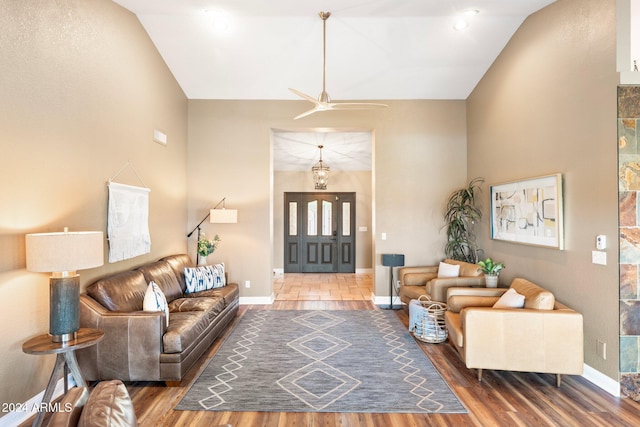 living room with hardwood / wood-style flooring, ceiling fan, and lofted ceiling