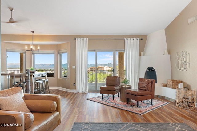 living room with a mountain view, hardwood / wood-style floors, lofted ceiling, and an inviting chandelier