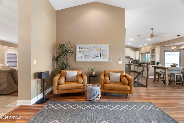 living room with lofted ceiling, hardwood / wood-style flooring, ceiling fan, and sink