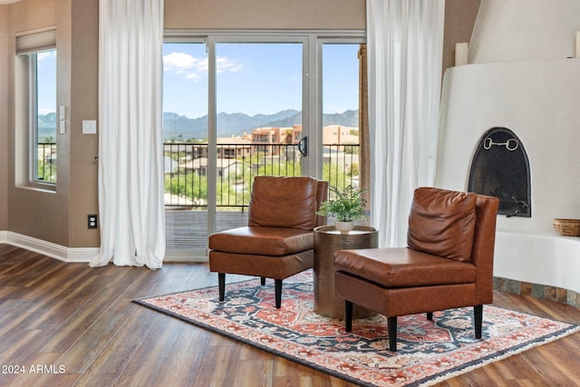 sitting room with dark hardwood / wood-style flooring, a mountain view, and plenty of natural light