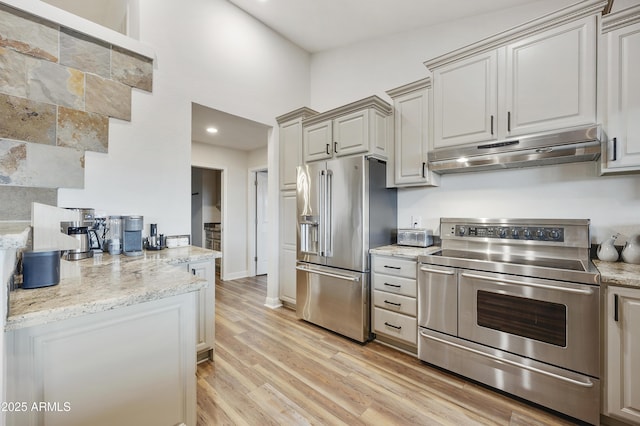 15857 E Ponderosa Dr, Fountain Hills, AZ 85268 - kitchen with stainless steel appliances, under cabinet range hood, light wood-style floors, and light stone countertops