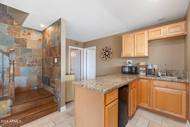 kitchen with light brown cabinets, light stone countertops, kitchen peninsula, and sink