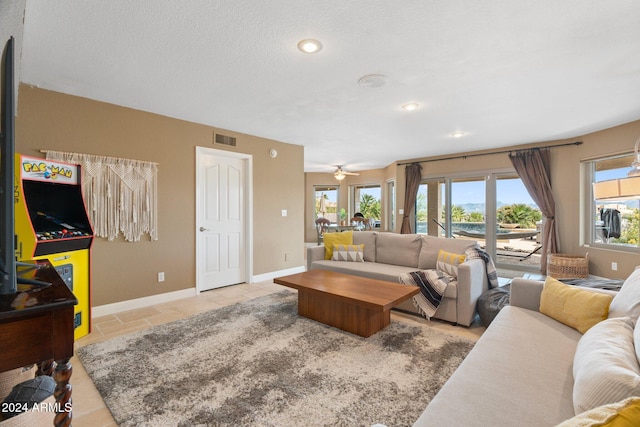 living room featuring a textured ceiling, a wealth of natural light, and ceiling fan